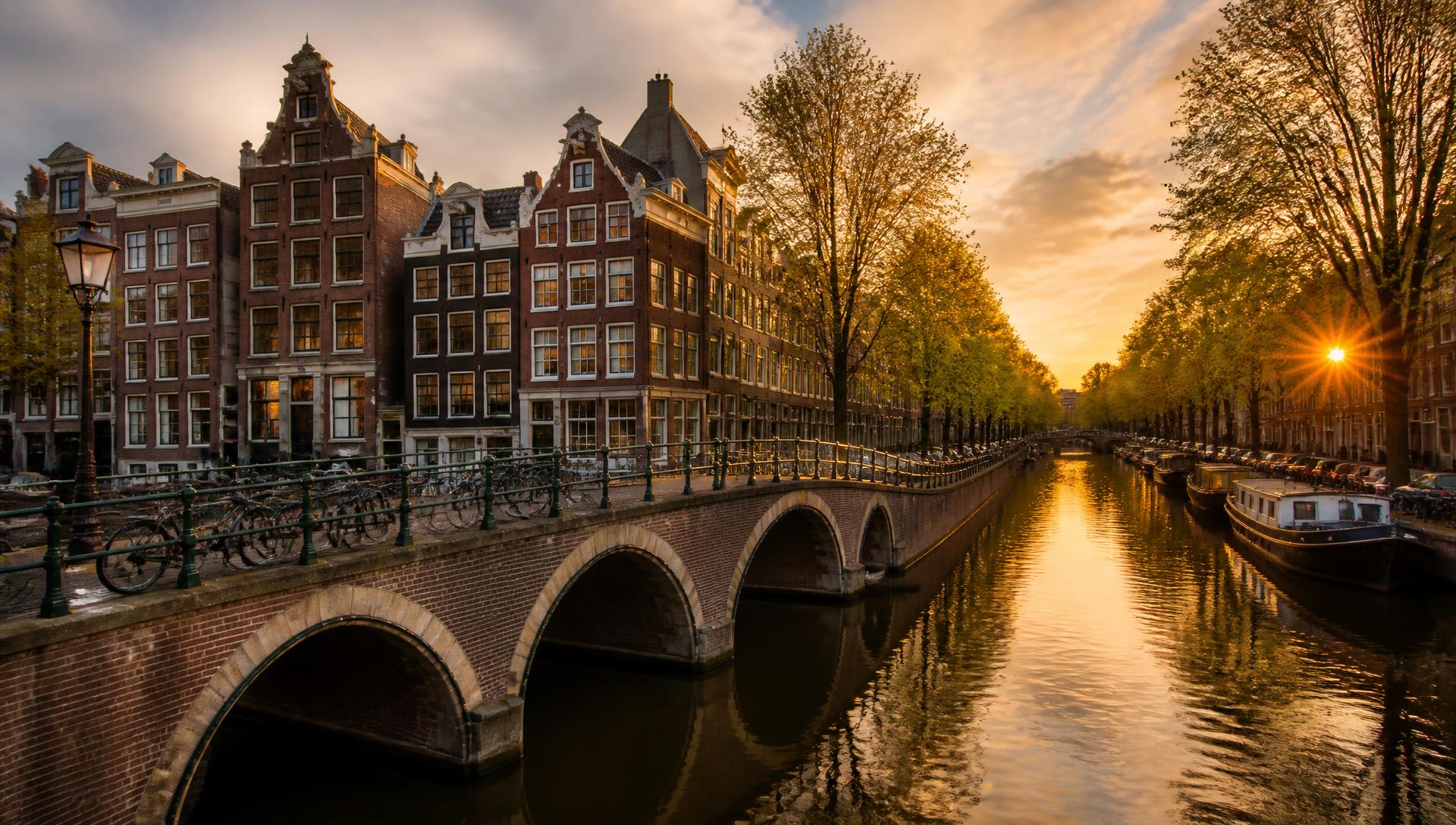 Amsterdam canal houses reflected in the water at golden hour